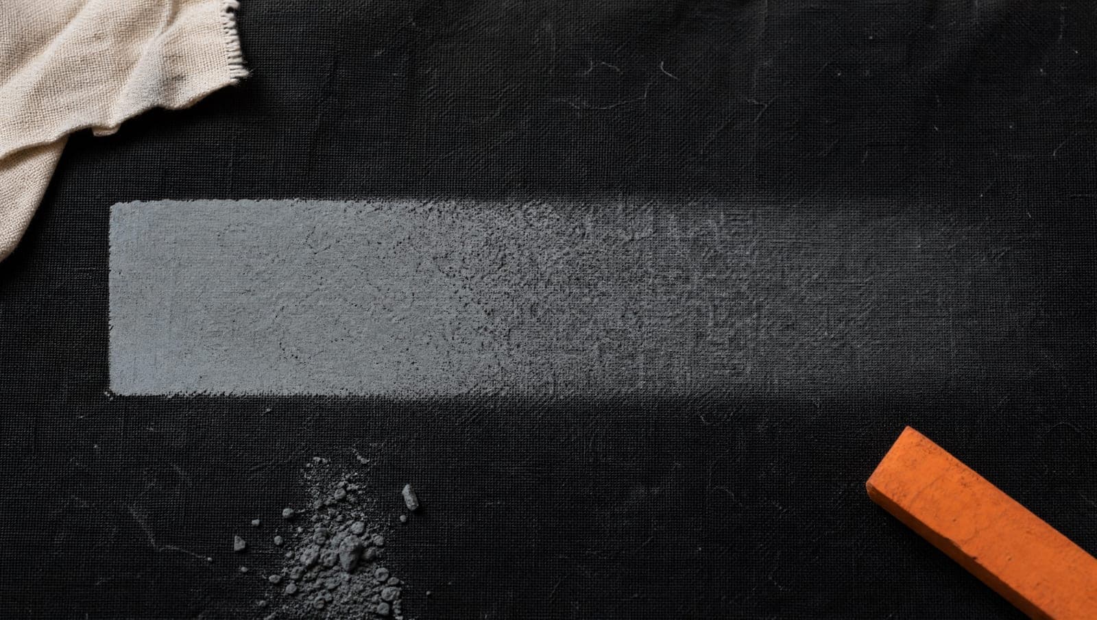 A band of pale pigment on dark cloth, crisp at one end and dissolved into an even haze at the other.