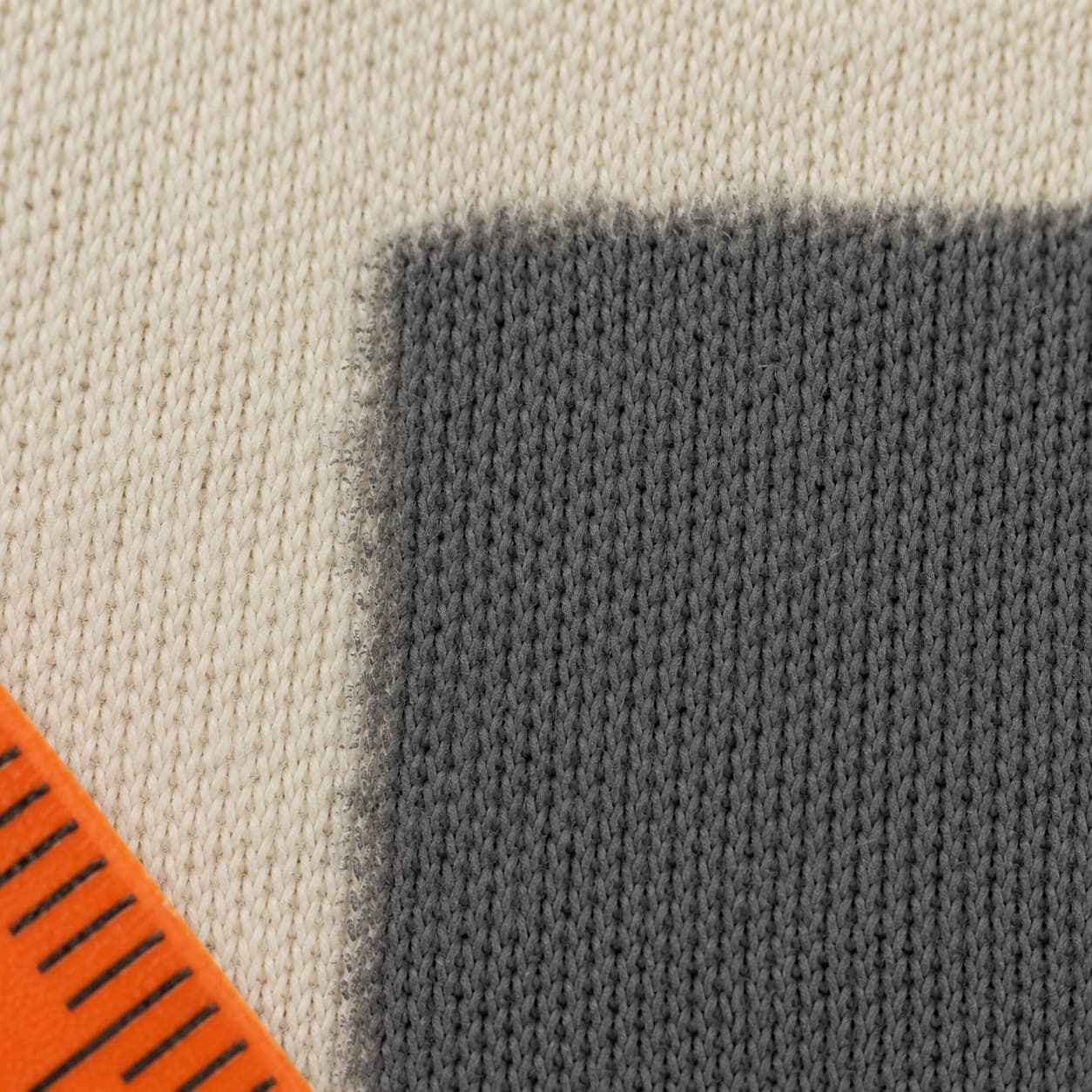 Macro of knitted jersey with a plain ink block whose edge has wicked slightly along the yarn.