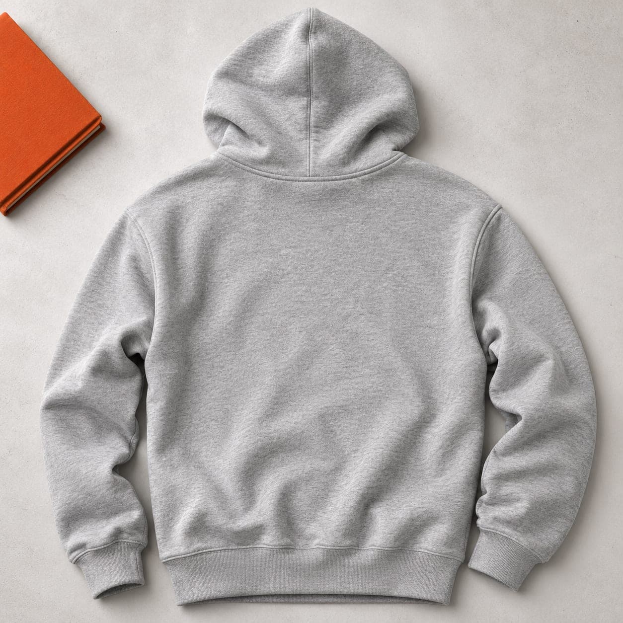A plain heather grey hoodie laid flat back side up, back panel blank and unprinted.
